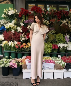 Détail d'une robe maxi en satin champagne avec col en V et texture lisse et soyeuse