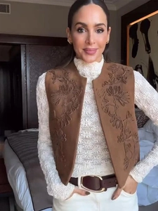 Close-up of vintage brown suede vest with intricate floral embroidery and open front design