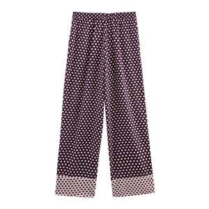 Detail of loose fit navy satin trousers with geometric diamond print and elastic waist