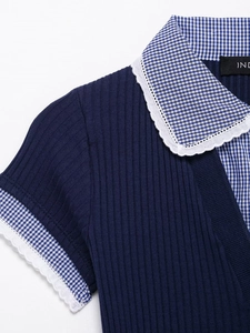 Dettaglio del top in maglia blu scuro con colletto gingham, pizzo e texture a coste