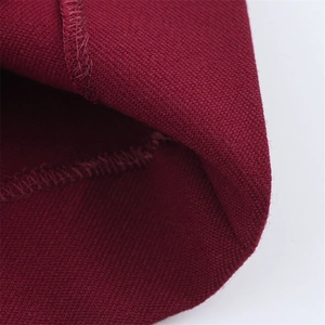 Gros plan du tissu de tailleur bordeaux montrant les coutures et la texture dense