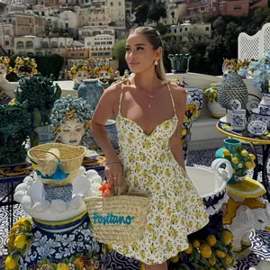 Chic yellow floral print poplin sundress with V-neckline and matching woven basket bag
