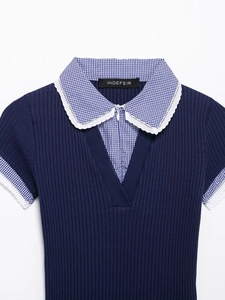Dettaglio top in maglia blu scuro con colletto a quadretti, pizzo e scollo a zip