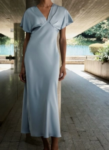 Détail de la robe longue en satin bleu clair avec col en V et manches bouffantes à volants
