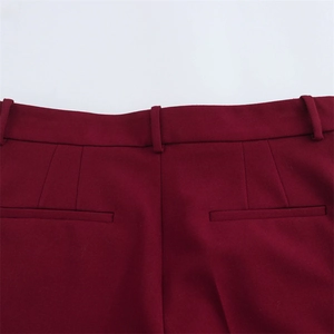 Détail de la taille arrière avec passants de ceinture et poches passepoilées sur pantalon bordeaux