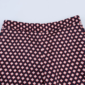 Detail of red and blue geometric print on a smooth satin trousers waistband