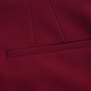 Détail macro de poche de blazer bordeaux avec coutures précises et texture de tissu en sergé