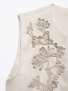 Close-up of beige vintage vest showing detailed 3D floral embroidery and fabric texture