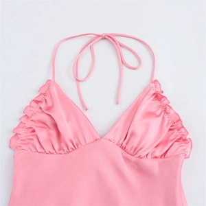 Vue détaillée du haut dos nu en satin rose avec bords à volants et décolleté en V