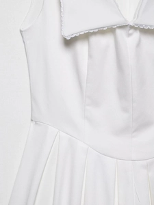 Détail de robe blanche avec col bordé de dentelle et taille plissée élégante