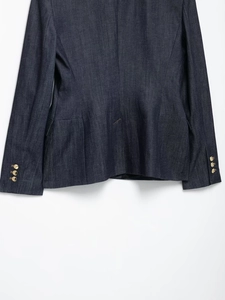 Détail du blazer en denim bleu foncé avec boutons dorés aux poignets et à l'ourlet
