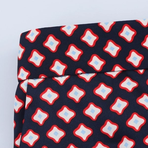 Detailed macro view of retro geometric print on navy blue satin fabric waistband