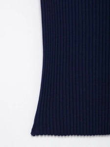 Dettaglio ravvicinato della trama in maglia a coste blu scuro della maglia a maniche corte