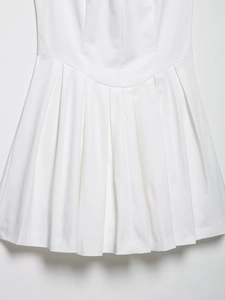 Détail de l'ourlet de la robe blanche à plis larges avec texture mate haut de gamme