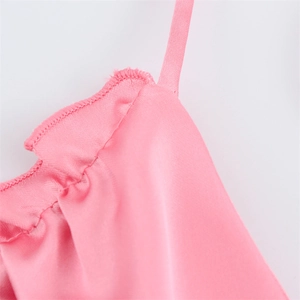 Vue macro des bretelles de robe en satin rose avec détails de couture à bord roulé