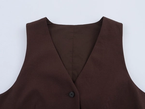 Detailed view of dark brown vest featuring a classic V-neckline and black button closure