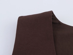 Detailed macro view of dark brown tank top fabric with fine stitching and cotton texture