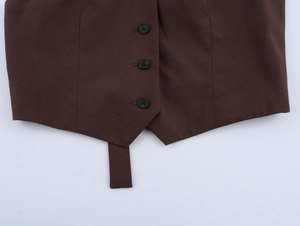 Close-up of brown slim vest showing three black buttons and detailed twill fabric texture