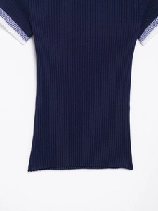Dettaglio della trama in maglia blu navy con maniche a quadretti e bordi in pizzo