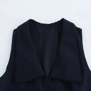 Detalle del cuello en V con delicado ribete de encaje negro en un vestido sin mangas