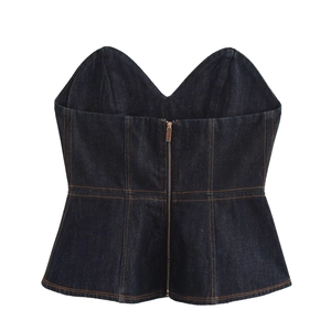 Détail d'un haut corset en denim bleu foncé avec coutures contrastées et zip métallique