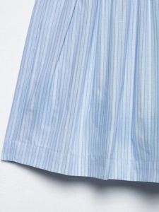Vue détaillée du tissu en coton à rayures bleu clair avec bord plissé et couture fine