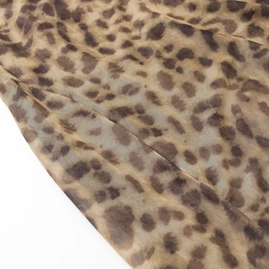 Détail du tissu en maille transparente à imprimé léopard sur une robe mi-longue