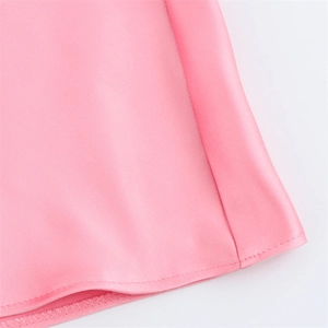 Détail de l'ourlet de la robe en satin rose montrant la couture et la texture lisse