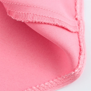 Détail de la couture surjetée soignée sur le tissu rose uni et lisse de la robe longue