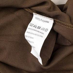 Détail de l'étiquette d'entretien indiquant 100% polyester et instructions de lavage