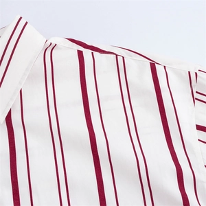 Detalle de la tela de camisa con rayas verticales granates sobre fondo de algodón blanco