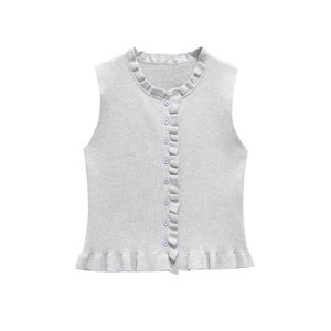 Detail of light grey knit vest featuring delicate ruffle trim and pearl buttons