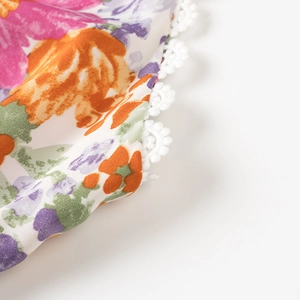 Macro détaillée d'un tissu à fleurs avec une bordure délicate en dentelle blanche fine