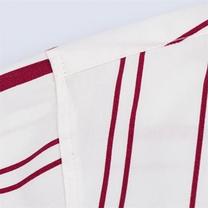 Detalle de rayas verticales rojas sobre tela de algodón blanco con costuras precisas