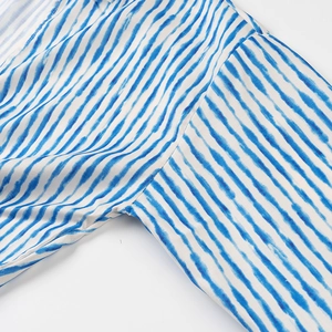 Close-up of blue and white striped fabric texture and shoulder seam on a summer shirt