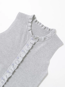 Detail of grey sleeveless knit top featuring ruffled collar and purple round buttons