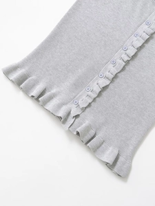 Close-up of ruffled hem and button-down detail on a soft grey knit sleeveless top