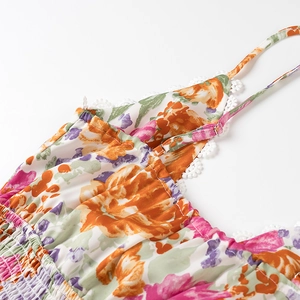 Détail d'une robe fleurie avec bustier smocké et bordure en dentelle blanche fine