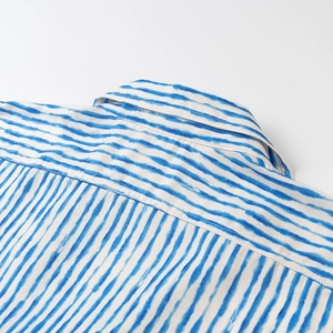 Close-up of blue tie-dye striped cotton linen shirt with refined collar stitching