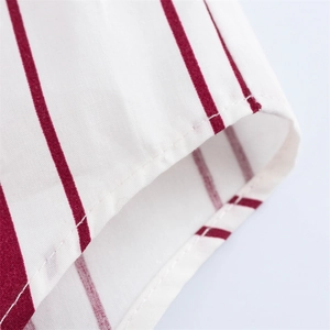 Detalle de una camisa de rayas verticales rojas y blancas con costuras de alta calidad