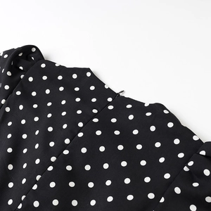 Detail des unsichtbaren Reißverschlusses und der weißen Polka Dots auf schwarzem Stoff