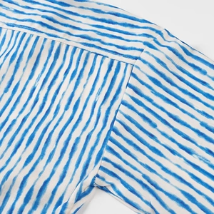 Macro shot of blue and white striped fabric showing detailed shoulder stitching and weave