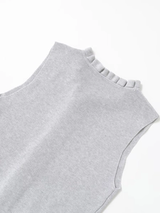 Close-up of the delicate ruffled collar and knit texture of a sleeveless grey top