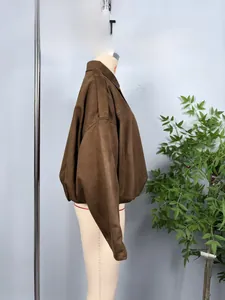 Detail of a brown suede bomber jacket featuring a ribbed hem and drop shoulder design