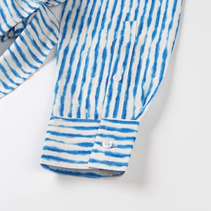 Macro detail of blue and white striped shirt cuff with elegant translucent buttons
