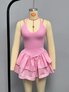 Detail of pink halter neck dress featuring ribbed knit texture and tiered ruffle hemline