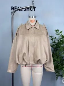 Detail of tan faux suede bomber jacket showing shoulder straps and soft matte texture