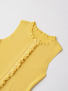 Detail view of the yellow knit sleeveless top with delicate ruffle trim and matching buttons