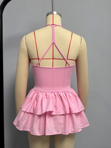 Detailed back view of pink ribbed knit dress with Y-strap tie design and ruffled hem