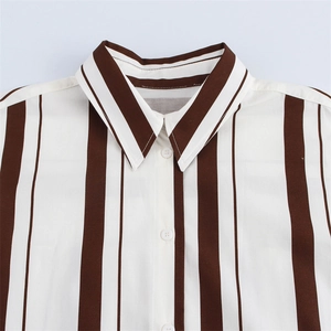 Primer plano del cuello de camisa de rayas verticales con botones blancos y rayas marrones